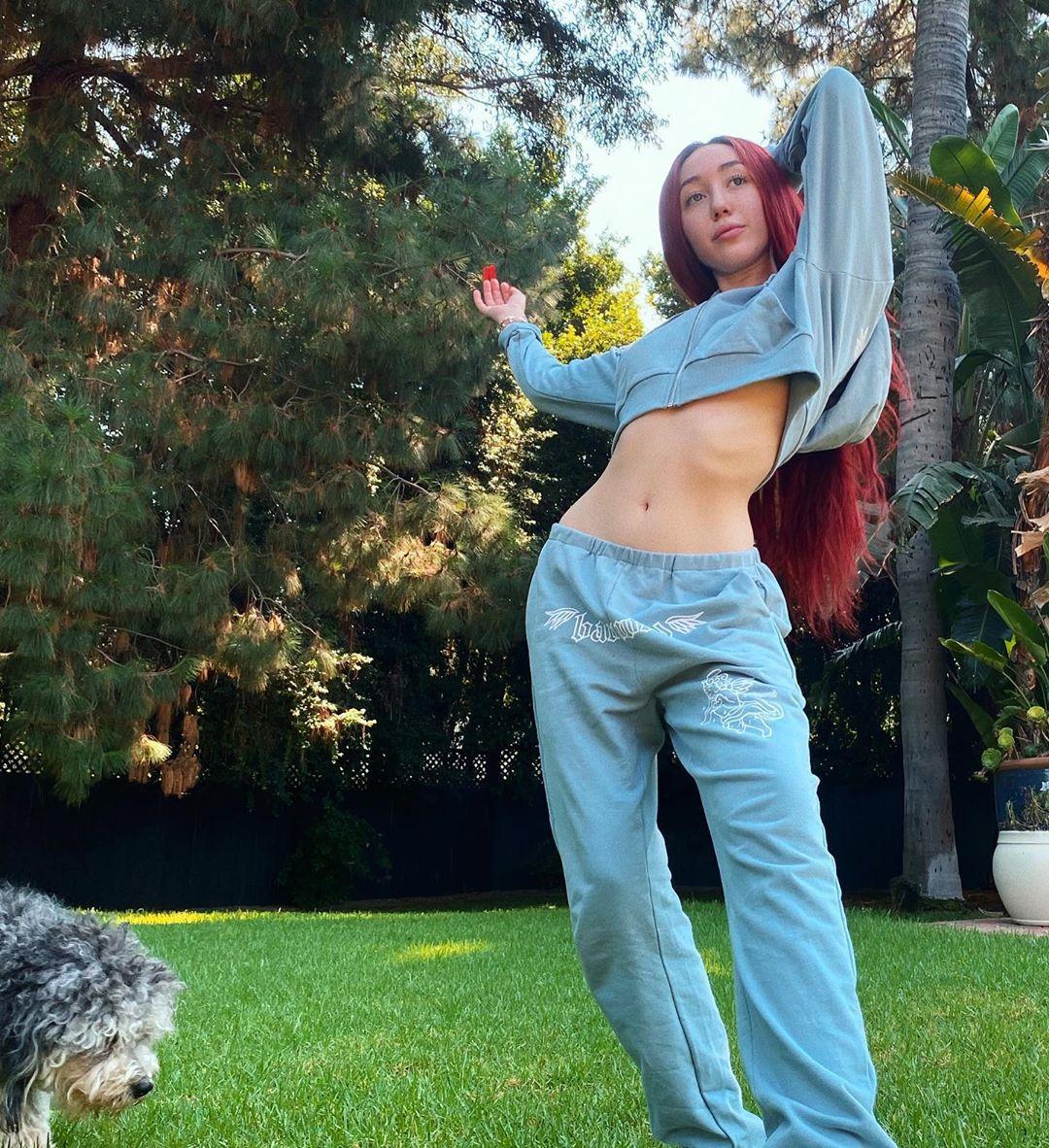 Noah Cyrus flashes her flat midsection in white sports bra